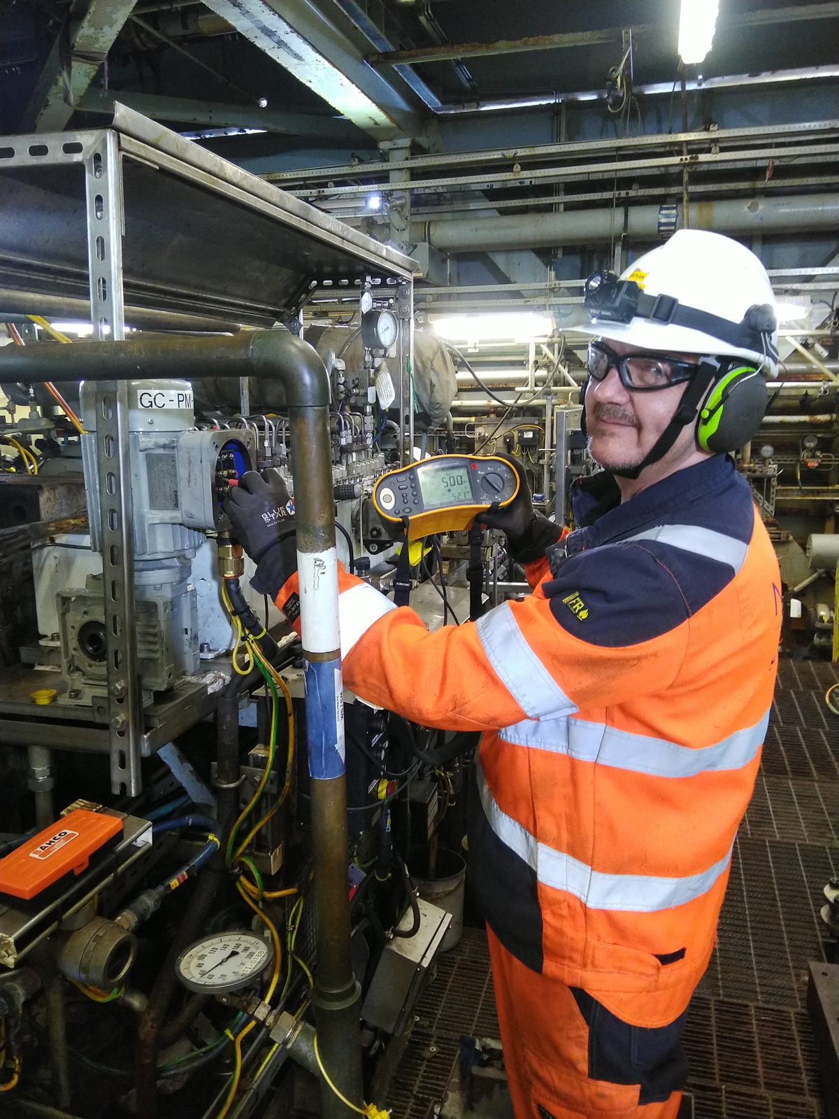 István Giblák performing insulation resistance measurement on an Ex motor on the platform, with a test instrument