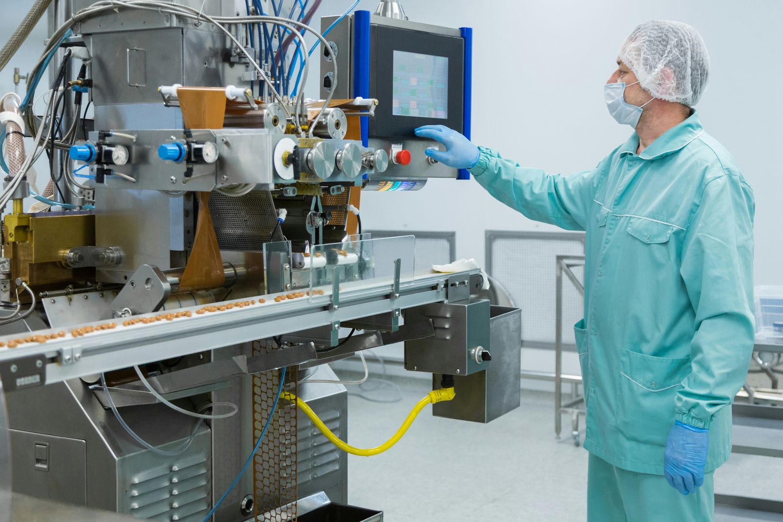 Pharmaceutical tableting and packaging line in a clean room, with an operator